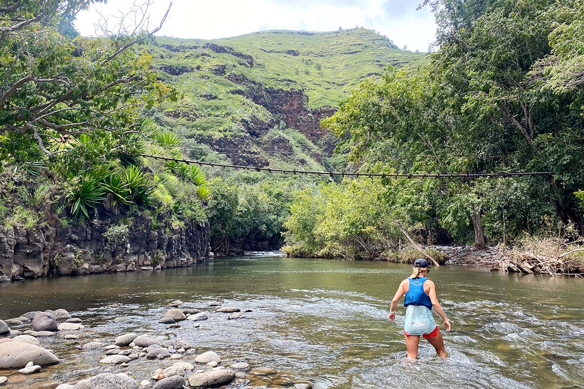Wading through stream while hiking in Kaua'i