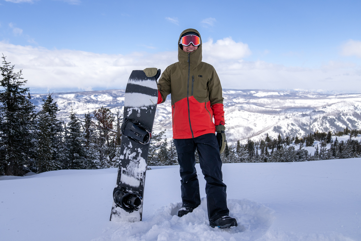 All-mountain Snowboards (holding up snowboard in snow)