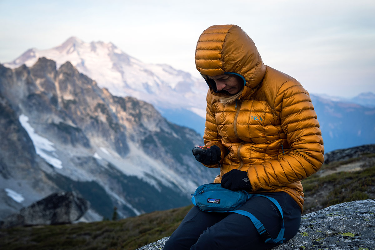 Women's down jacket (checking GPS device wearing Rab Mythic Alpine Light)