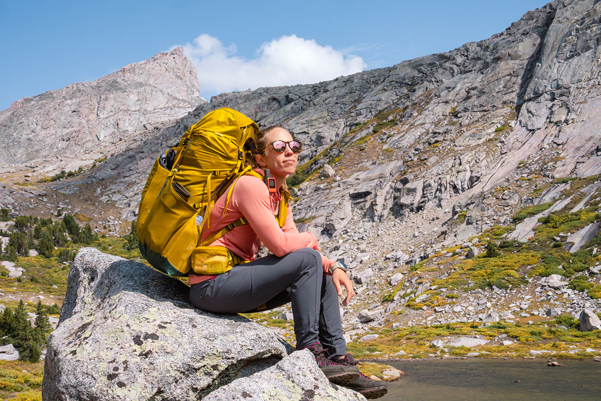 Women's hiking pants (sitting on rock wearing Rab Elevation)