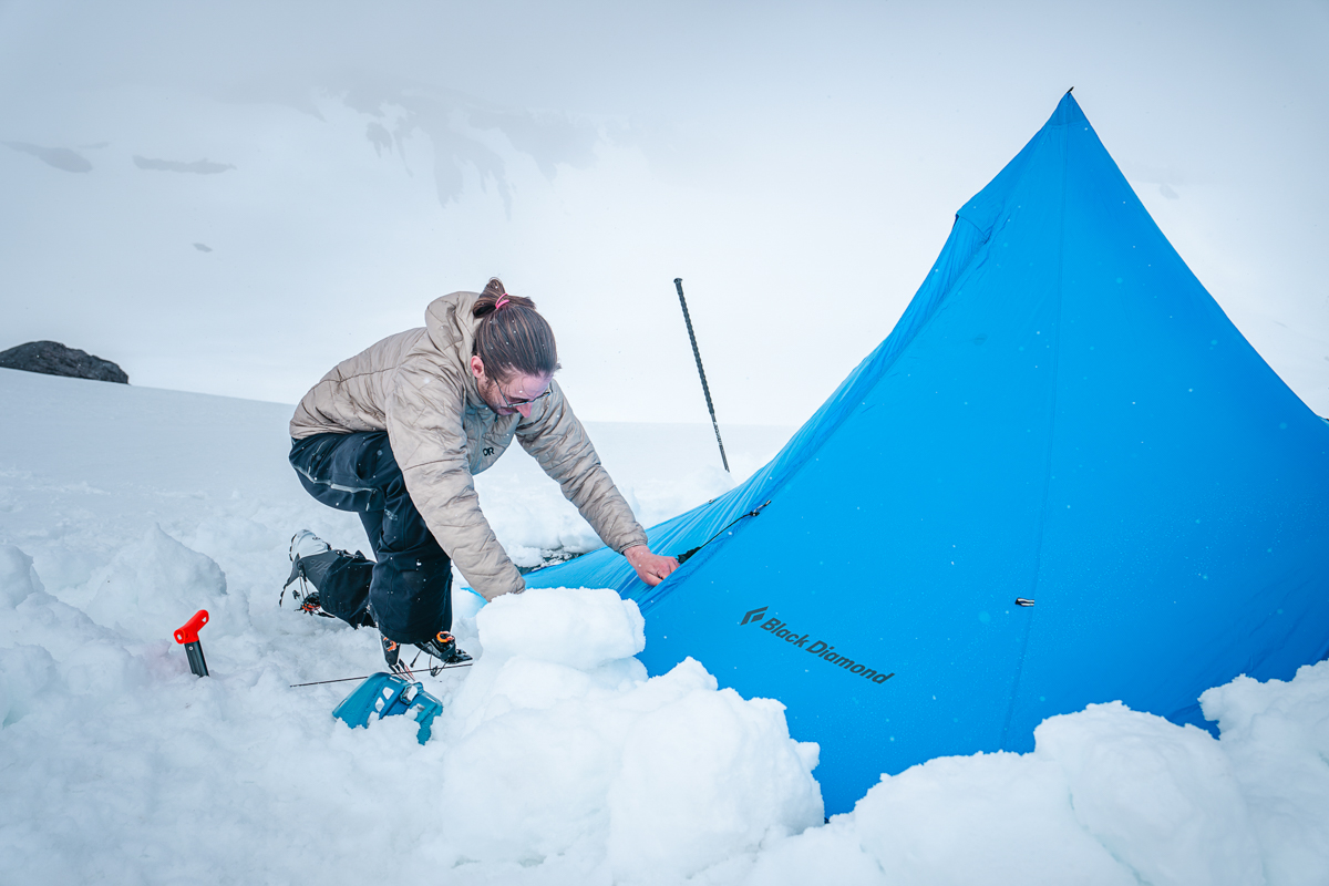 Outdoor Research Skytour AscentShell Bib (kneeling in snow before tent)