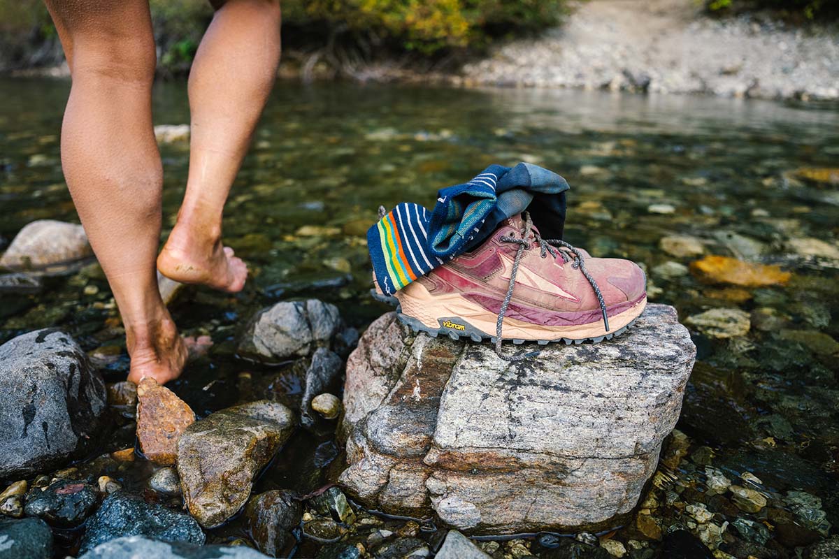 Waterproof hiking footwear (Altra Olympus 5 Low GTX sitting on rock near water)