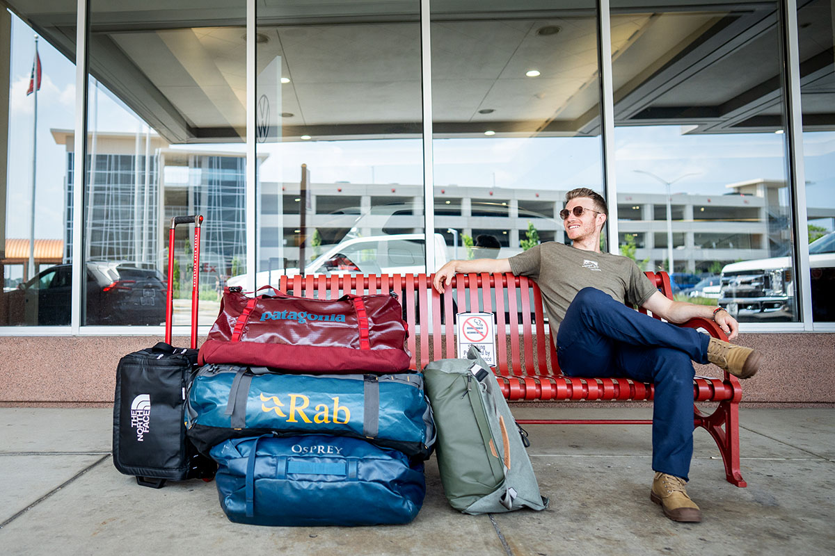 Duffel bags (sitting on bench at airport with group of duffels)