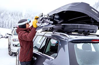 Yakima SkyBox NX 16 roof box (putting snowboard in box)